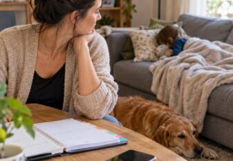 Professionnelle indépendante du bien-être animal à la maison près de son enfant malade, avec son agenda de rendez-vous sur la table